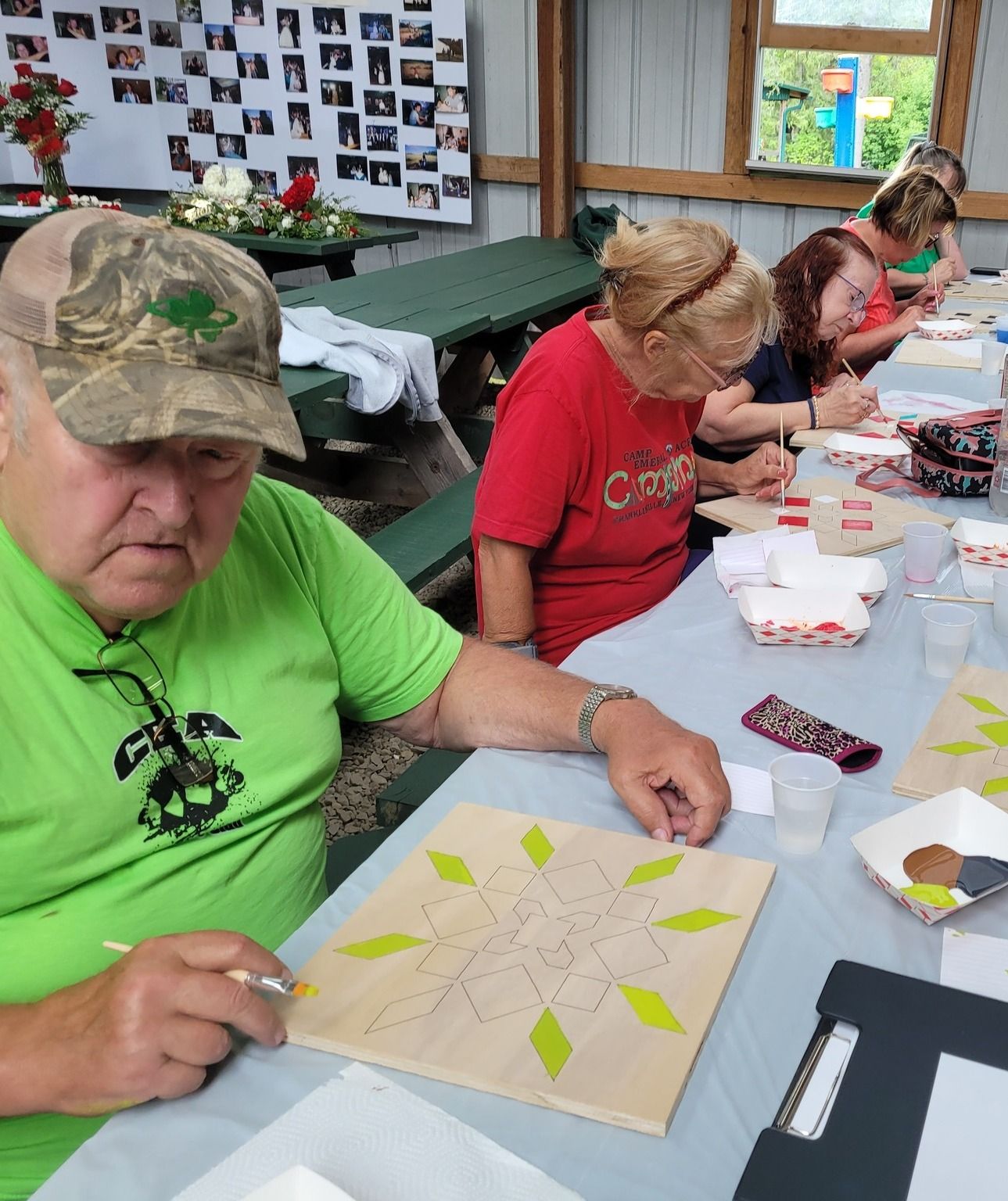 Campers painting together at a paint night in the pavilion