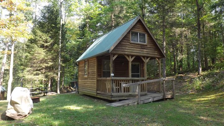 Rustic wooden rental cabin with a green roof